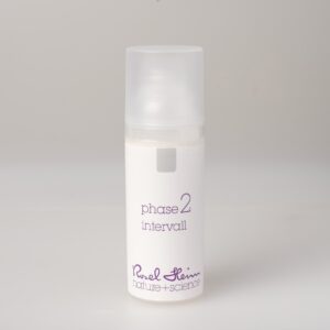 Eine kleine, zylindrische, weiße Flasche mit mattiertem Deckel und der Aufschrift „intervall Avocadoöl parfümfrei 50ml Phase 2“ in violetter Schrift. Der Produktaufdruck auf der Unterseite lautet „Ruel Heim nature + science“. Die Flasche steht auf einem schlichten, hellgrauen Hintergrund.